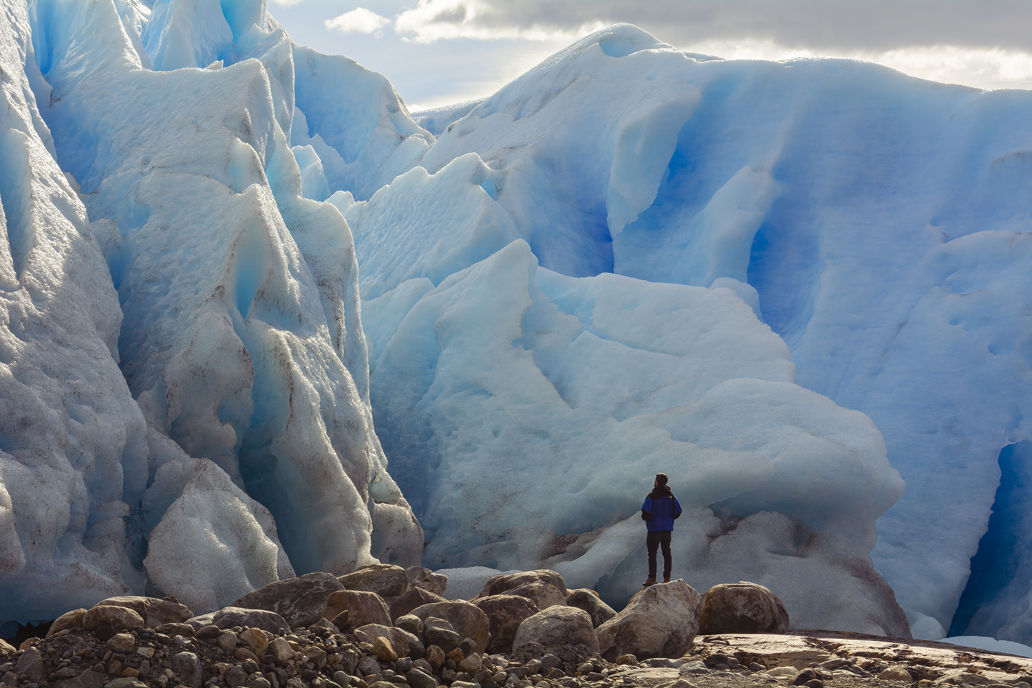Caminante pequeño frente a la pared de hielo azul del glaciar Perito Moreno