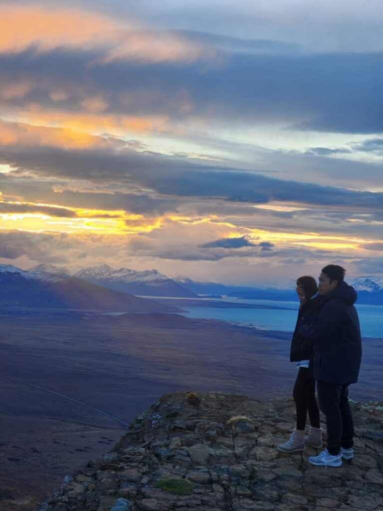 Pareja en un mirador de los Balcones de El Calafate al atardecer sobre el lago Argentino